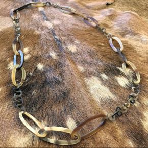 Handgemaakt buffelhoorn collier in bruintonen. Matte finish, lichtgewicht. Lengte 116 cm.