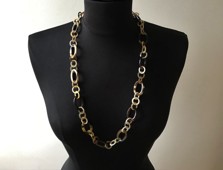 Sierlijke handgemaakte buffelhoorn ketting. Lichte tintjes. Shiny finish, lichtgewicht. Lengte 80cm.