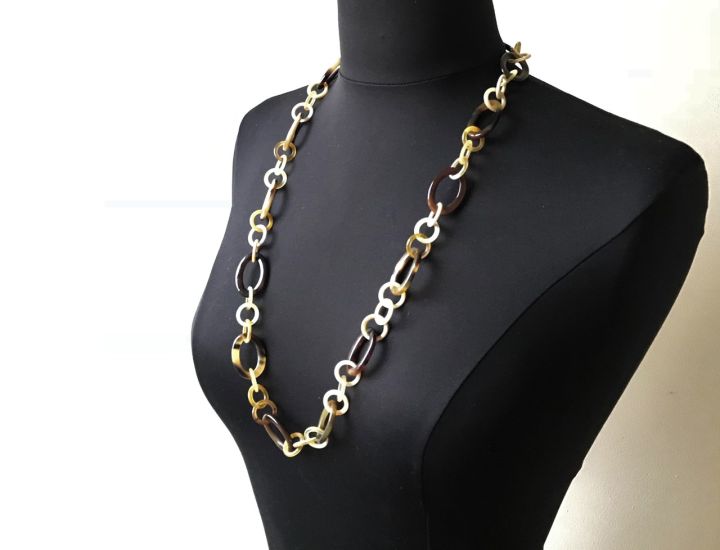 Sierlijke handgemaakte buffelhoorn ketting. Lichte tintjes. Shiny finish, lichtgewicht. Lengte 80cm.