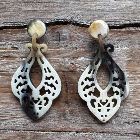 Sierlijk bewerkte buffelhoorn oorbellen 7.3x3.7 cm. Kleurvariaties. Matte finish. Lichtgewicht.