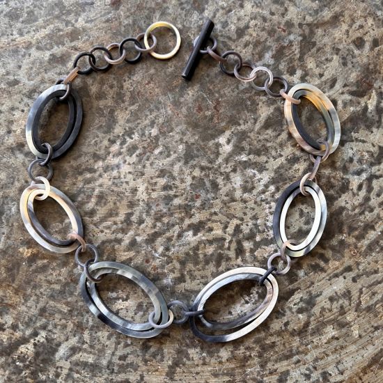 Sierlijk buffelhoorn collier. Gemixte tintjes. Matte finish. Lichtgewicht. Lengte: 62 cm.