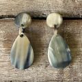 Handgemaakte druppelvormige buffelhoorn oorbellen. Totale lengte 6cm, incl stud. Mixed tintjes, mat.