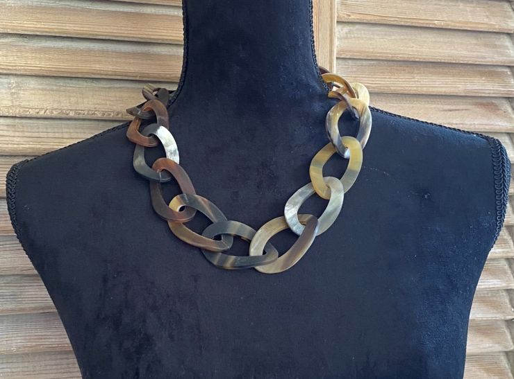 Handgemaakt buffelhoorn collier, bruintinten. Matte finish. Schakels hebben een twist. 65cm.