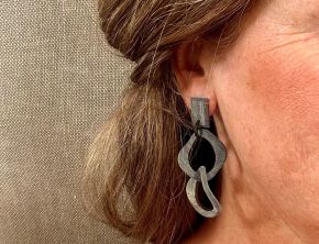 Geborstelde buffelhoorn schakeloorbellen met een twist. 7 x 3 cm. Facetgeslepen stud