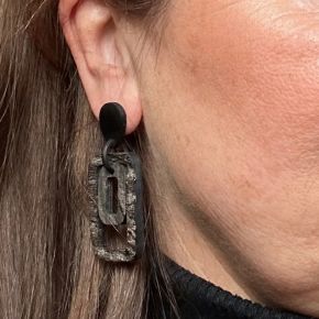 Handgemaakte, ruwe buffelhoorn oorbellen, met mat zwarte studs. Totale lengte 6x2.5 cm.