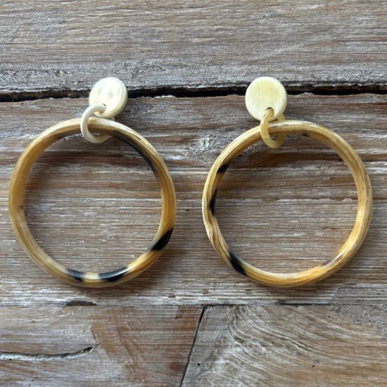 Handgemaakte buffelhoorn creolen in gevarieerde tintjes, +/-6 cm. Glanzend. Totale lengte 8 cm.