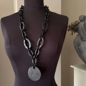 Handgemaakt buffelhoorn collier met Ø6cm hanger, in een matte & ruwe finish. Lengte 80 cm.