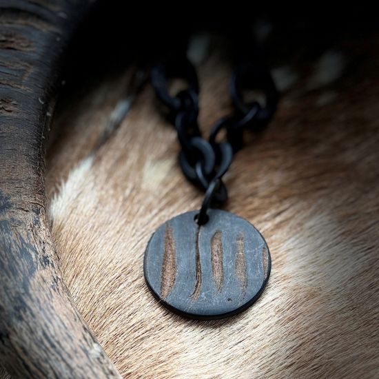 Handgemaakt buffelhoorn collier met Ø6cm hanger, in een matte & ruwe finish. Lengte 80 cm.