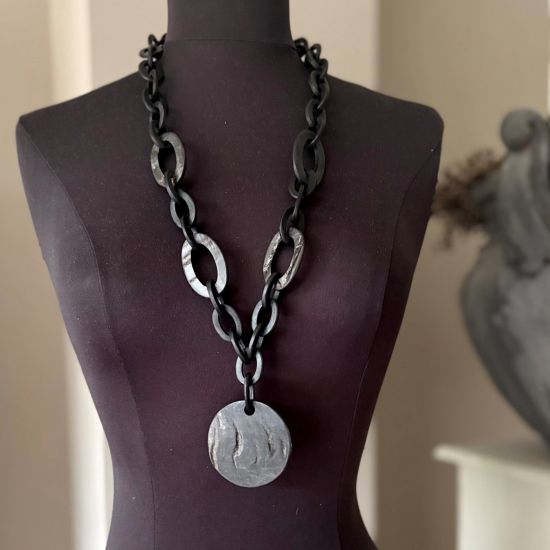 Handgemaakt buffelhoorn collier met Ø6cm hanger, in een matte & ruwe finish. Lengte 80 cm.