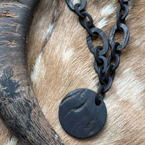 Handgemaakt buffelhoorn collier met Ø6cm hanger, in een matte & ruwe finish. Lengte 80 cm.